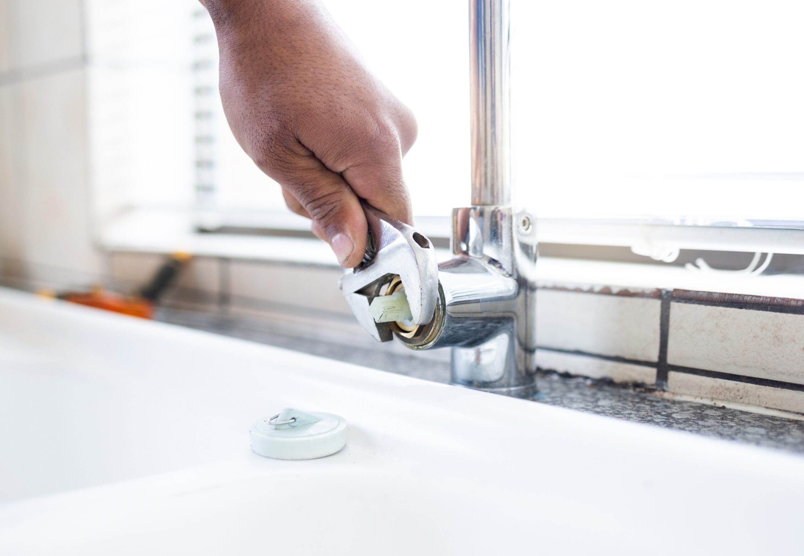 Faucet, wrench and plumber hand, plumbing and maintenance for kitchen sink, trade and manual labour.